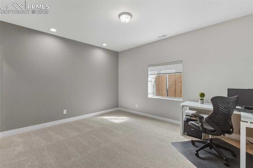 Image 41 of 49: Office space featuring light colored carpet and recessed lighting