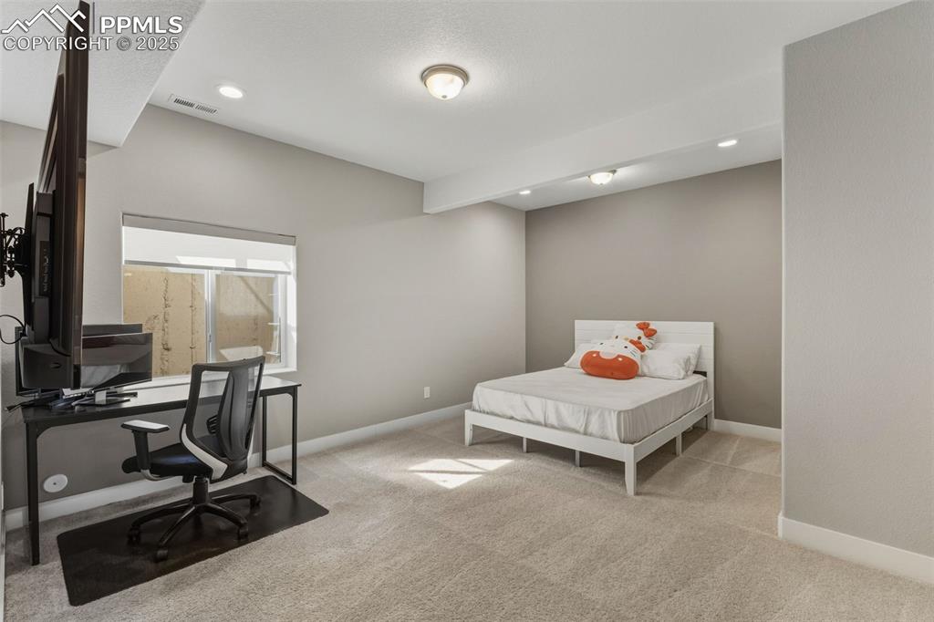 Image 44 of 49: Bedroom featuring light colored carpet, recessed lighting, an office area, 