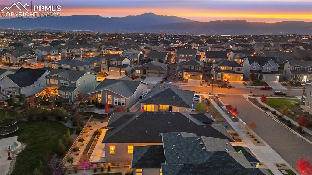 Image 7 of 49: Aerial view of residential area featuring a mountain backdrop