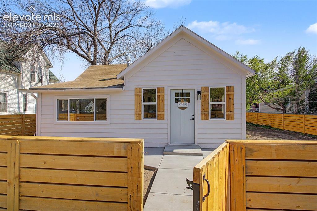 Image 1 of 26: White siding exterior with a light blue entry door featuring a window inser