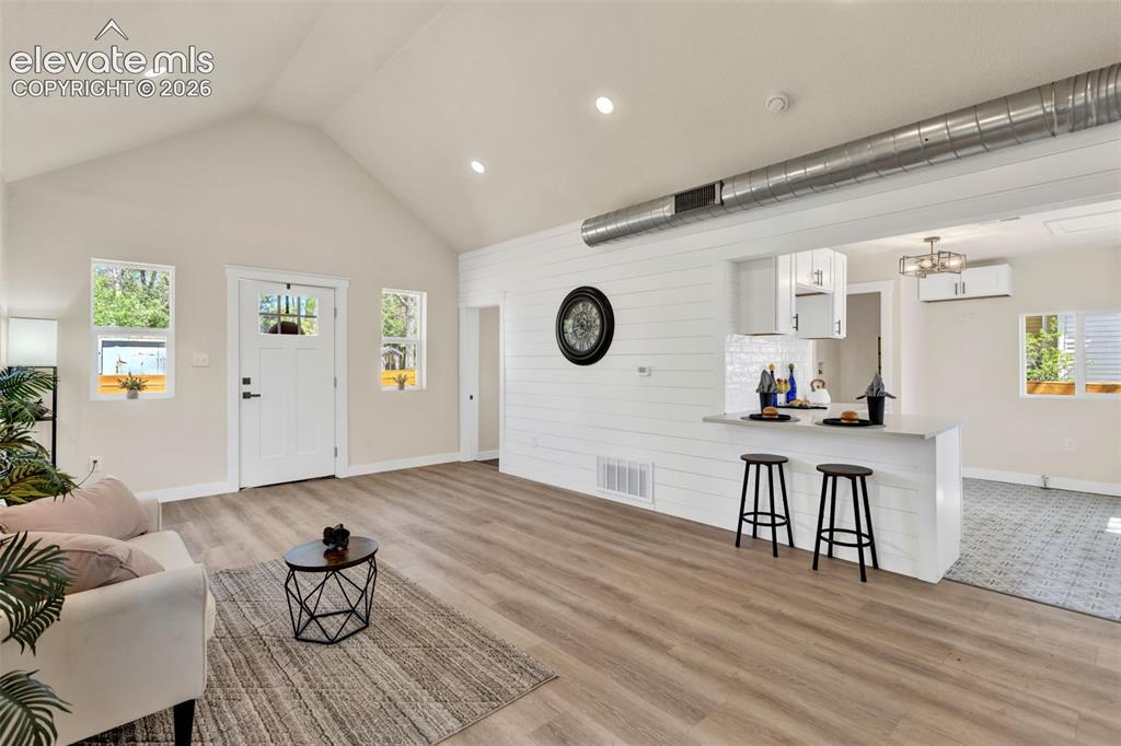 Image 11 of 26: Open-concept living area with vaulted ceilings and recessed lighting