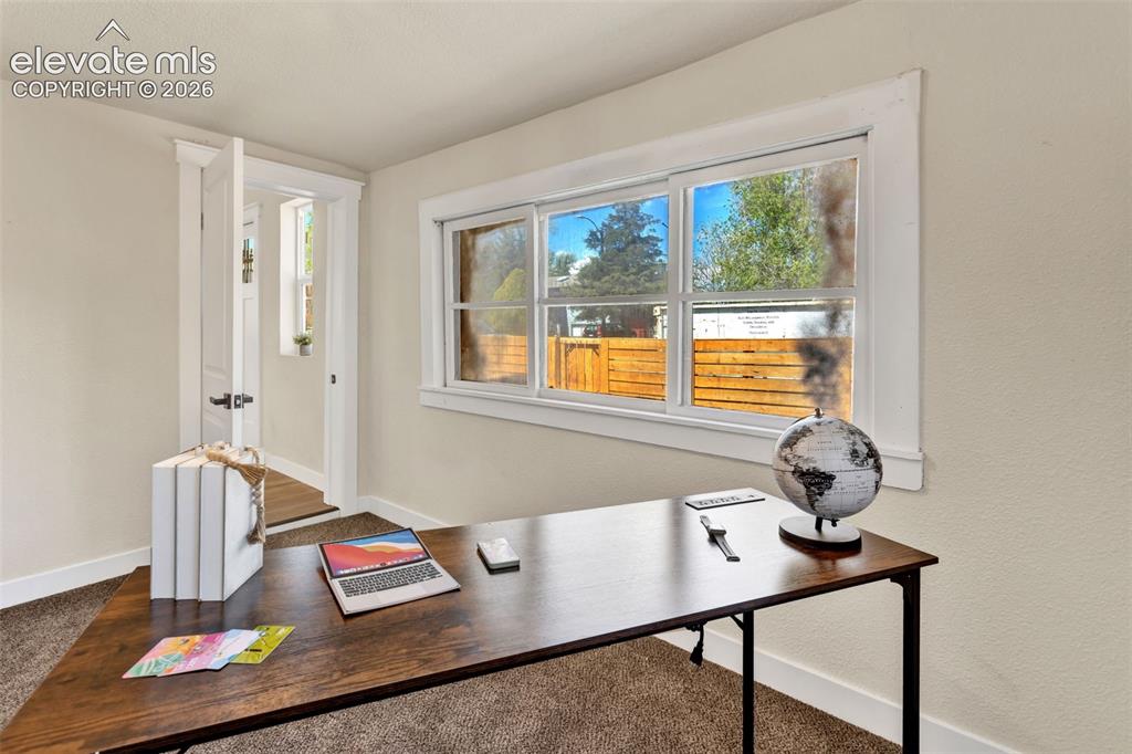 Image 18 of 26: Bright room featuring a large window with white trim, soft neutral wall ton