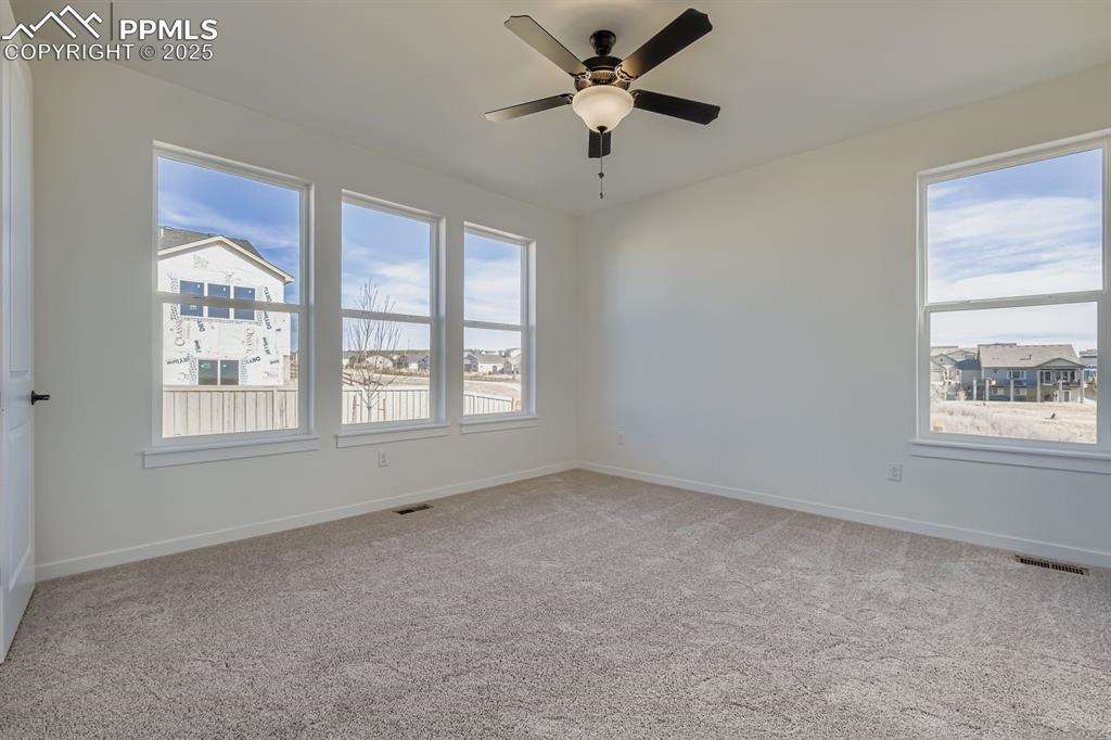 Image 12 of 27: Spare room with light colored carpet and a ceiling fan
