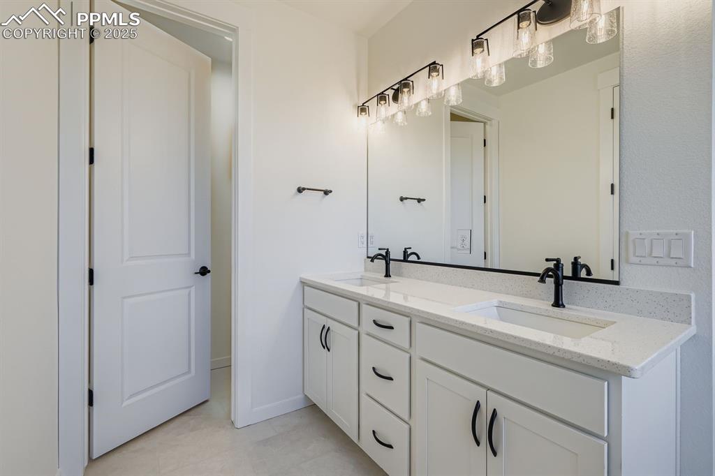 Image 13 of 27: Bathroom featuring double vanity and light tile patterned floors