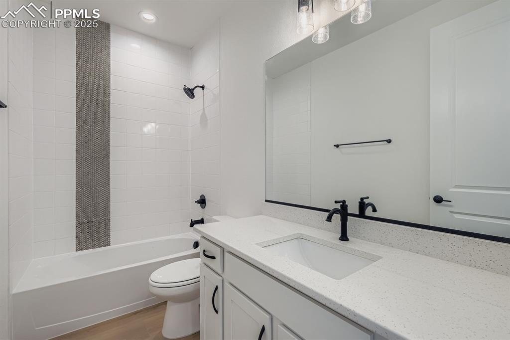Image 17 of 27: Bathroom featuring vanity, tub / shower combination, light wood-style floor