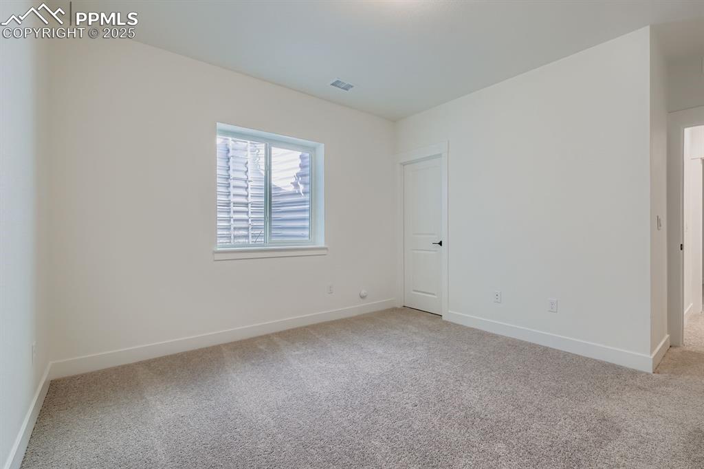 Image 20 of 27: Spare room featuring baseboards and light carpet