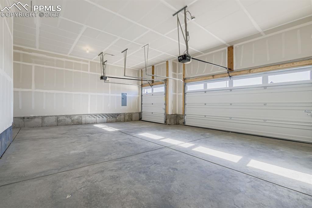 Image 25 of 27: Garage featuring electric panel and a garage door opener