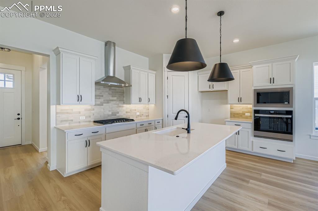 Image 7 of 27: Kitchen featuring tasteful backsplash, stainless steel appliances, white ca