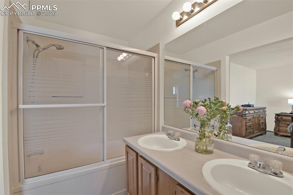 Image 19 of 38: Primary Bathroom with Dual Vanity and Tub Shower Combo.