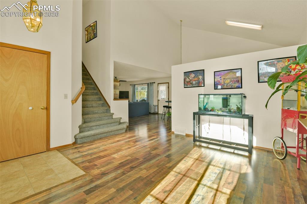 Image 3 of 38: A light and bright entry to the livingroom with new LVP flooring and vaulte