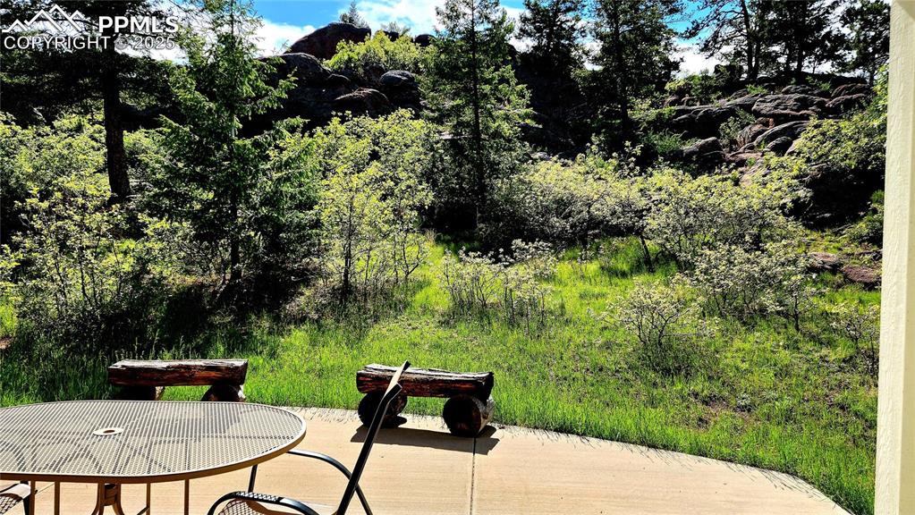 Image 4 of 50: incredible back yard covered porch with rock outcropping views