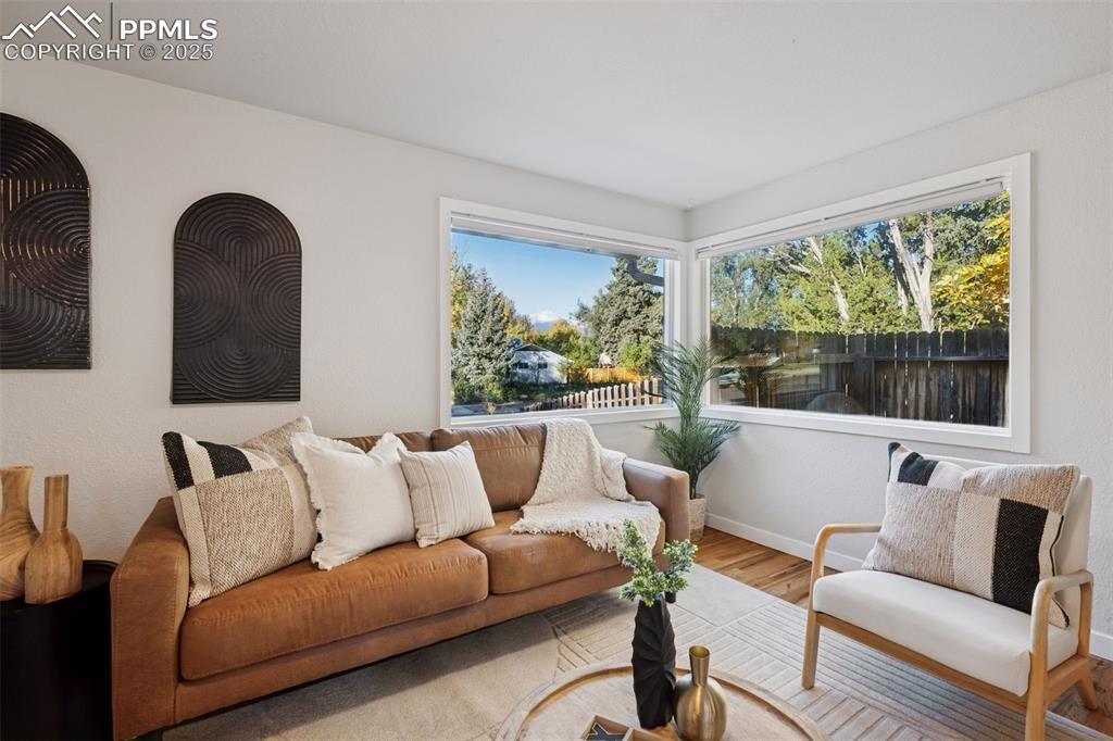 Image 10 of 20: Living area featuring wood finished floors and healthy amount of natural li