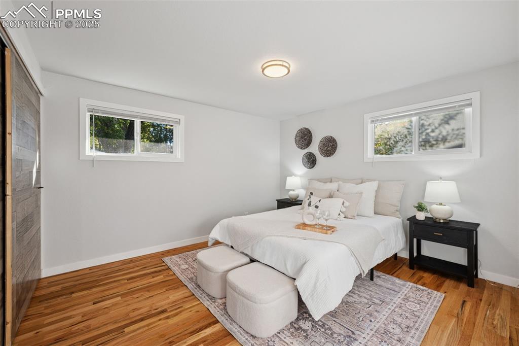 Image 16 of 20: Bedroom with multiple windows and wood finished floors