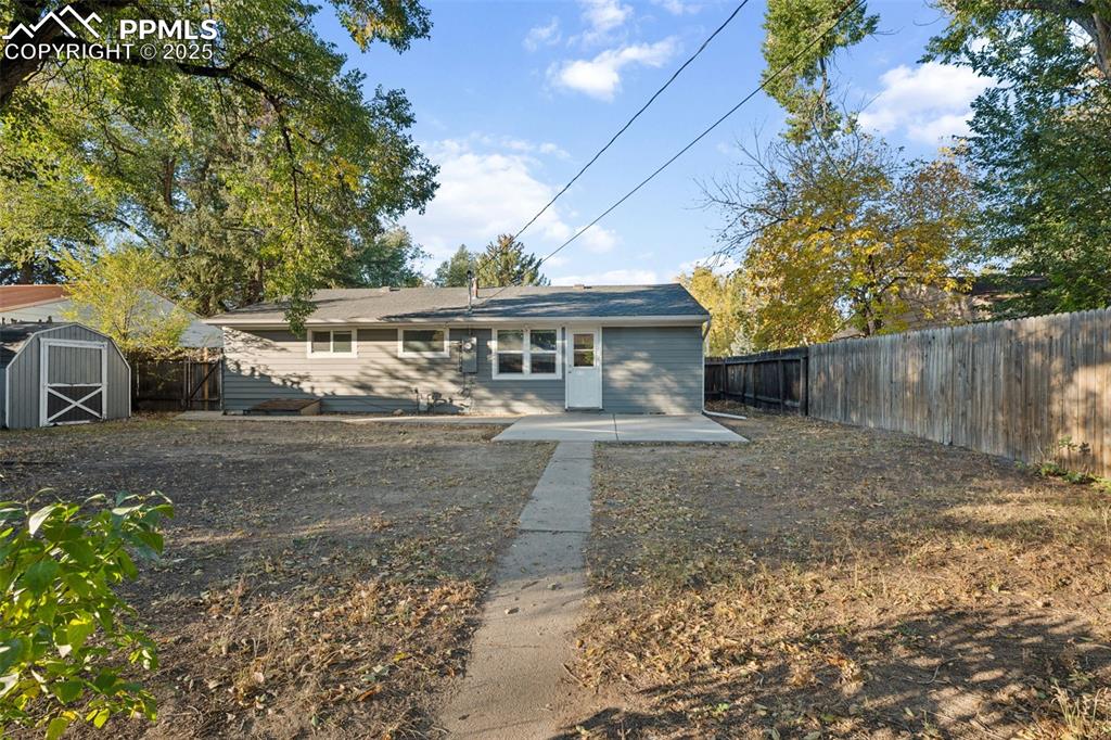 Image 5 of 20: View of back of home featuring a storage shed, a patio, and a fenced backya