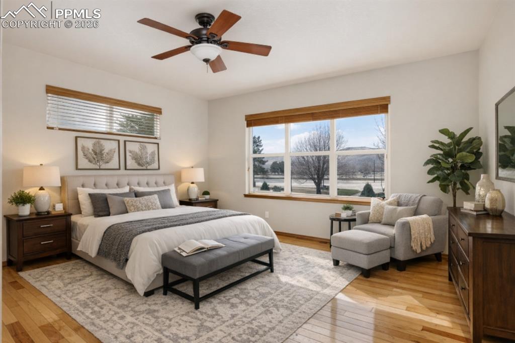Image 11 of 22: Bedroom with light wood-type flooring, a ceiling fan, and multiple windows