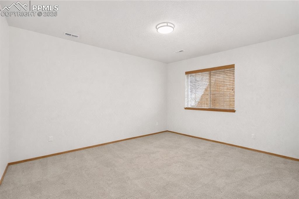 Image 14 of 22: Spare room with light carpet and a textured ceiling