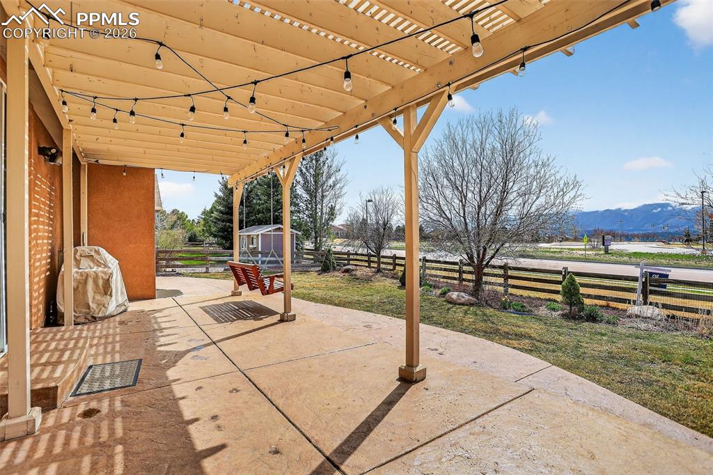 Image 17 of 22: Fenced backyard featuring a patio, a storage unit, a mountain view, and a p