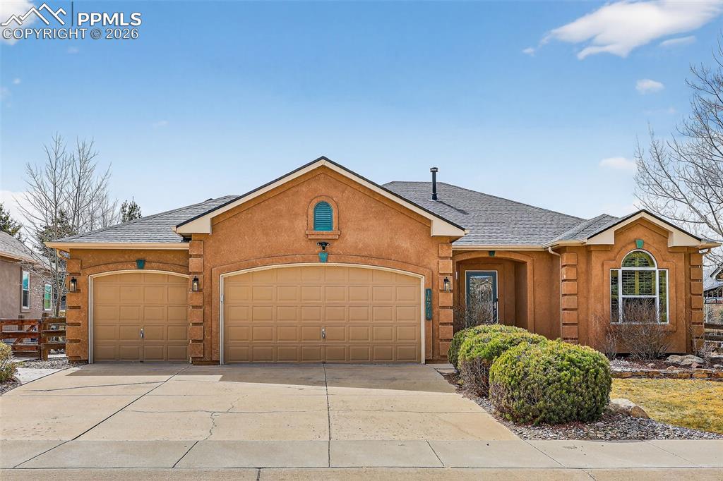 Image 2 of 22: View of front of home with roof with shingles, an attached garage, driveway