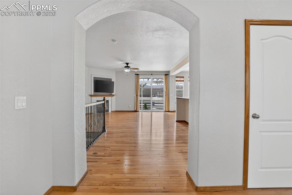 Image 3 of 22: Hall featuring a textured wall, light wood finished floors, and a textured