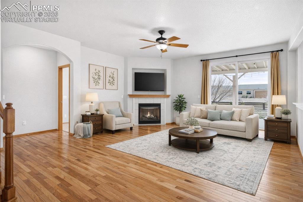 Image 5 of 22: Virtually Staged
Living room featuring light wood finished floors, a fire