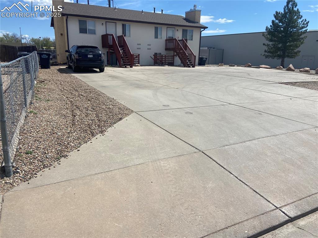 Image 2 of 8: View of building with large parking lot.