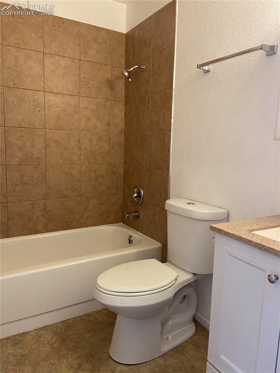 Image 3 of 8: Bathroom with shower / bathing tub combination, a textured wall, vanity, an