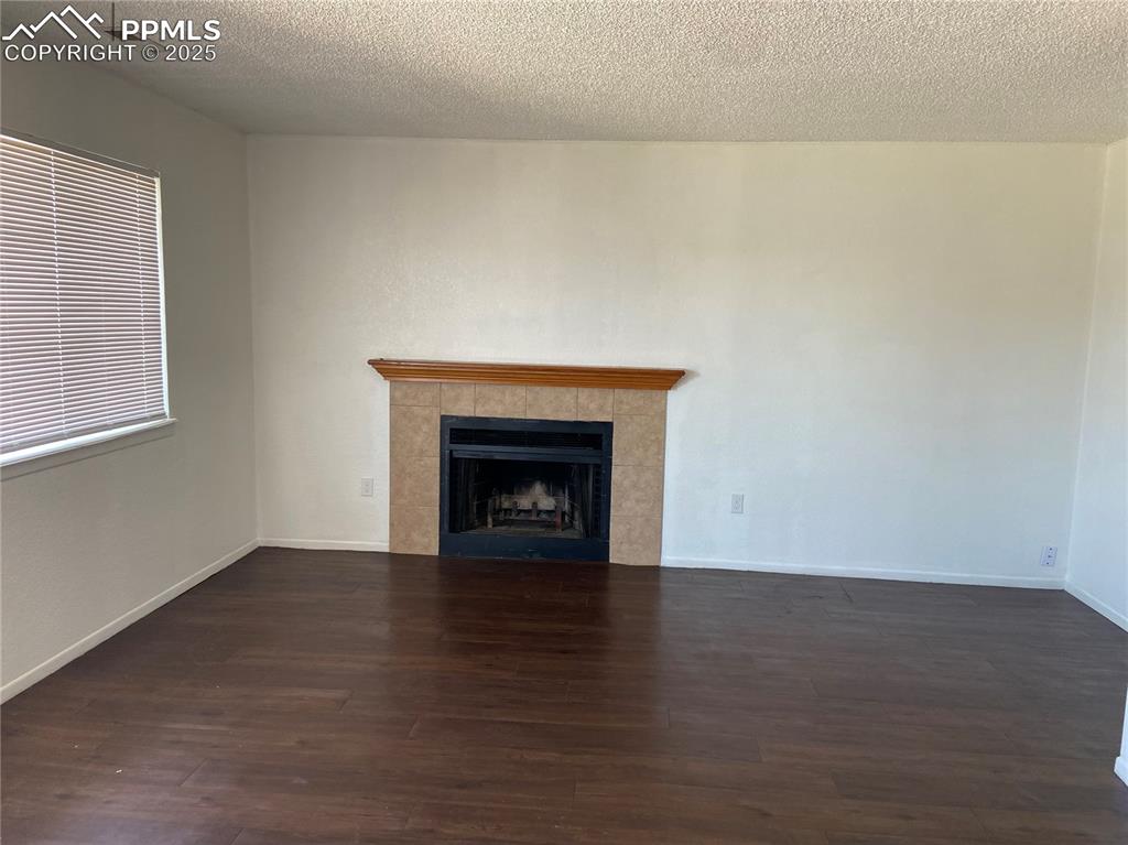 Image 8 of 8: Large living room with visible vents, wood finished floors, a fireplace, an