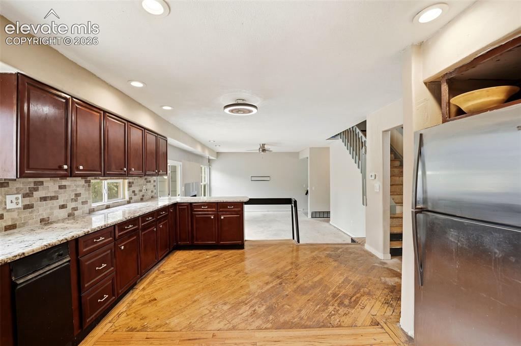 Image 13 of 34: Kitchen featuring wood-finish flooring, dark wood cabinetry, light-toned co
