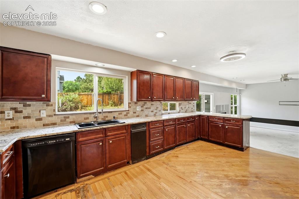 Image 14 of 34: Spacious kitchen featuring rich wood cabinetry, granite countertops, tile b