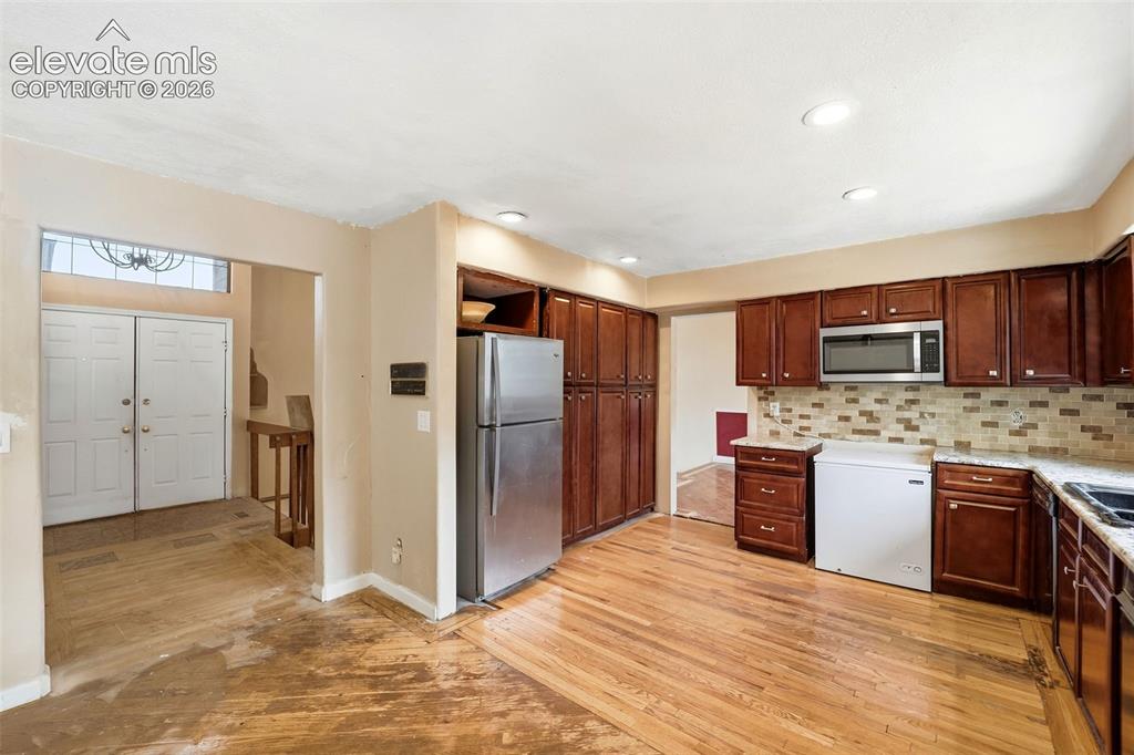 Image 15 of 34: Kitchen featuring wood-finish flooring, recessed lighting, wood cabinetry,