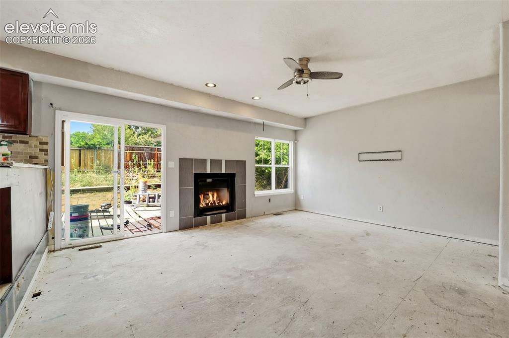 Image 17 of 34: Recessed lighting, ceiling fan, and sliding glass door
