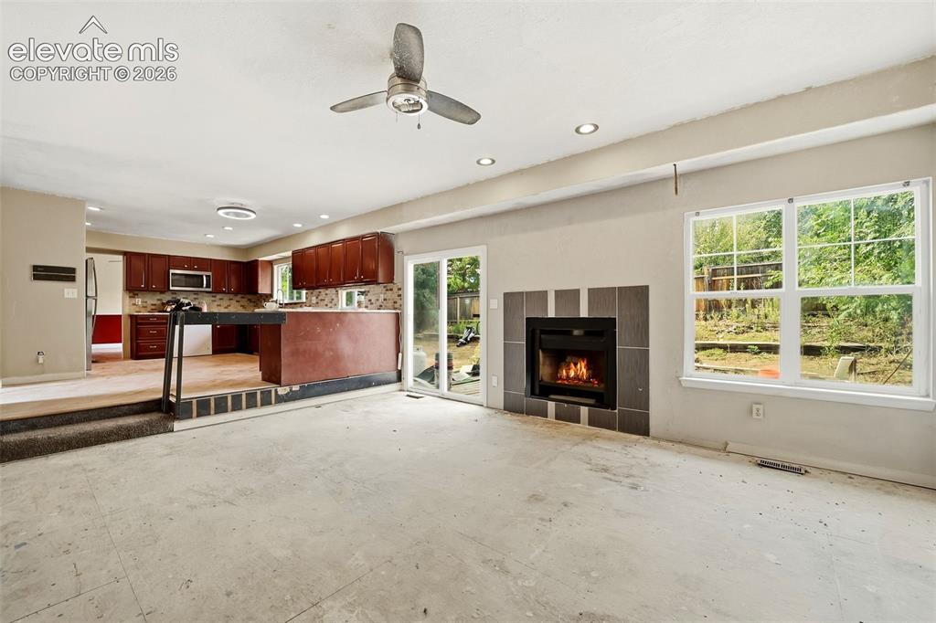 Image 18 of 34: Recessed lighting, ceiling fan, and large windows
