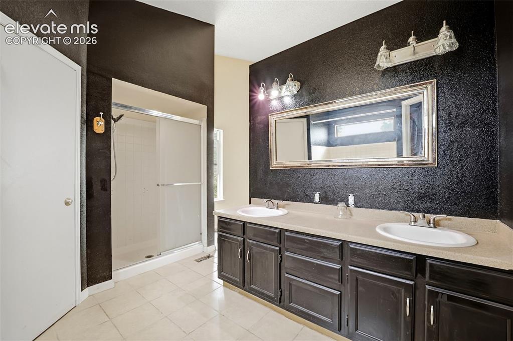 Image 27 of 34: Dual vanity with integrated sinks, framed mirror, and chrome fixtures