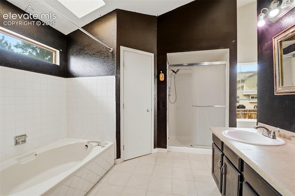 Image 28 of 34: Bathroom featuring a built-in bathtub with white tile surround, a separate