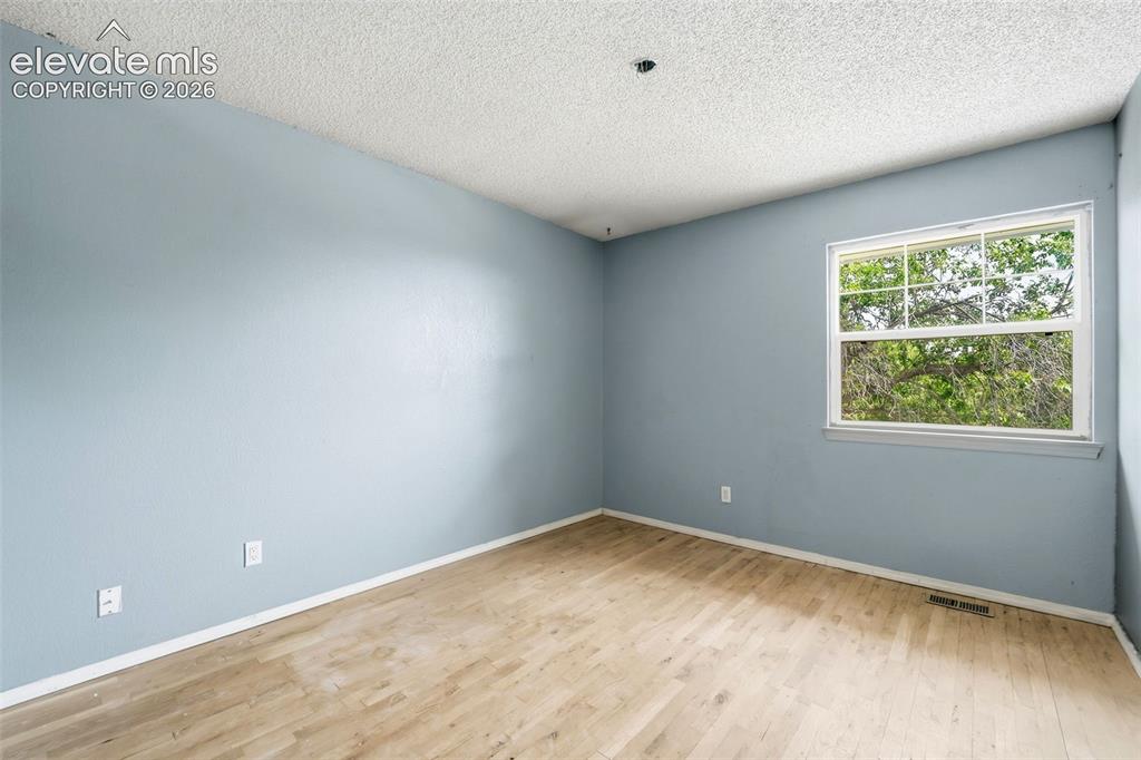 Image 31 of 34: Light wood-finish flooring with a single window