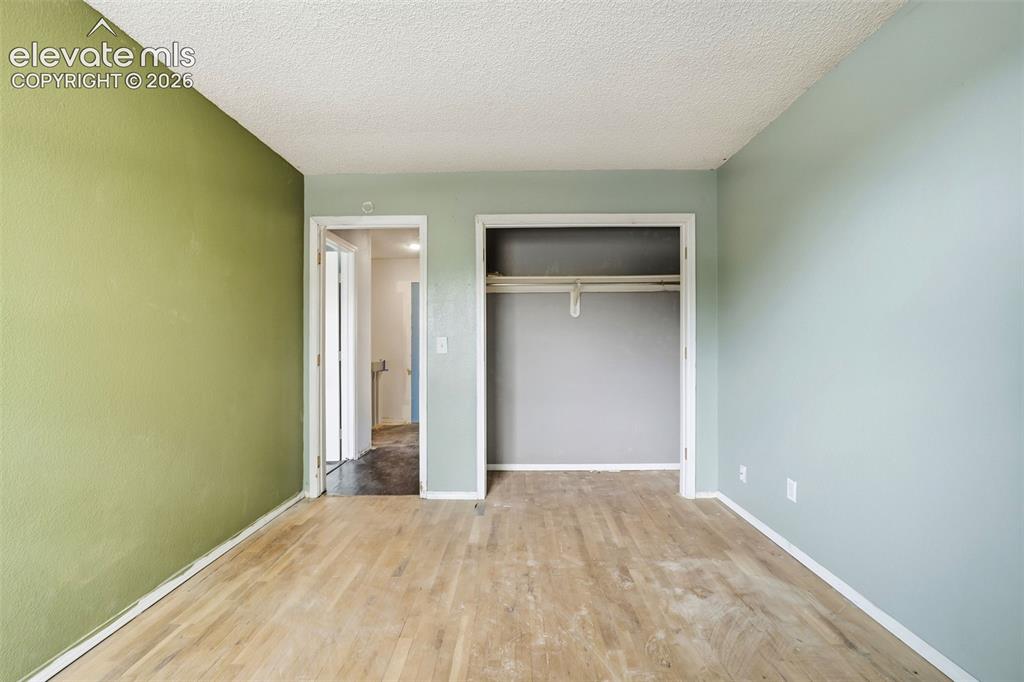 Image 33 of 34: Wood-finish flooring with varying wall tones and a built-in closet