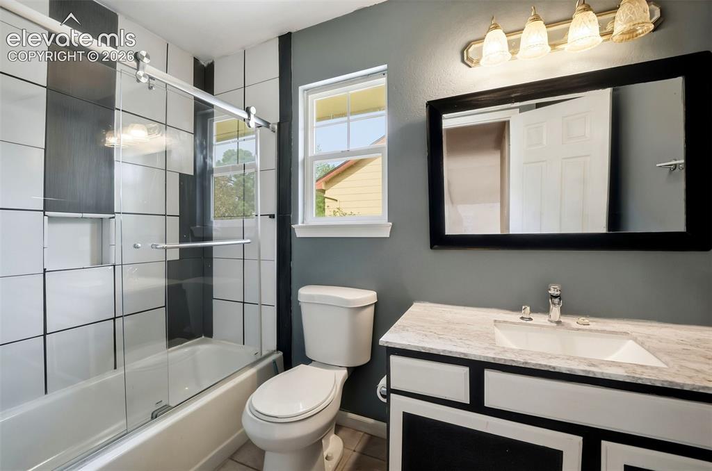 Image 34 of 34: Bathroom featuring a tub/shower combination with sliding glass doors, a sin