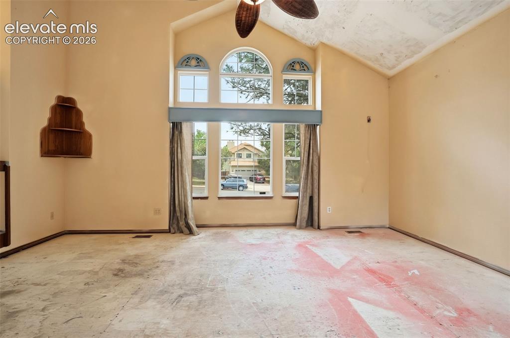 Image 7 of 34: Vaulted ceiling with a ceiling fan, arched transom windows, and a built-in 