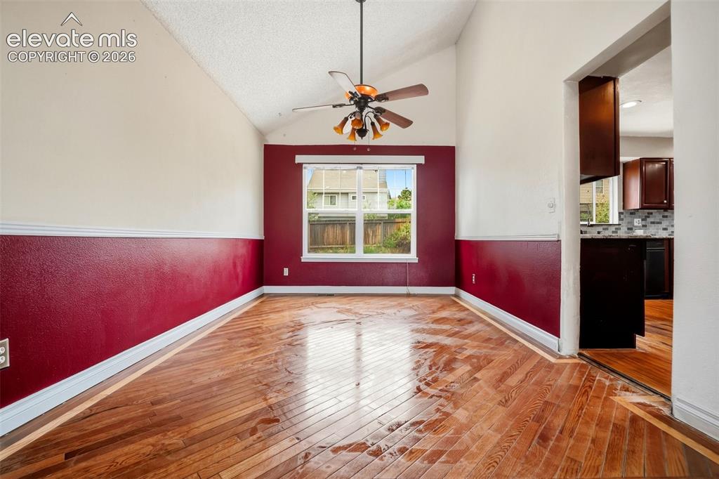 Image 8 of 34: Vaulted ceiling with a ceiling fan, wood-finish flooring, and a window with