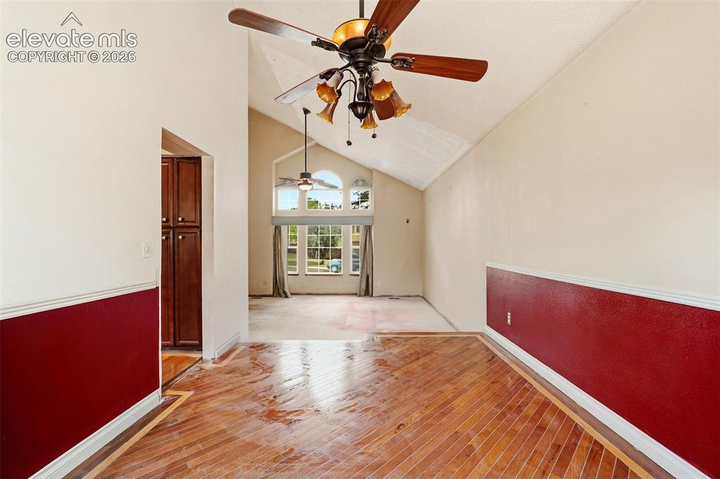 Image 9 of 34: Vaulted ceilings, wood-finish flooring, built-in cabinetry, and large windo