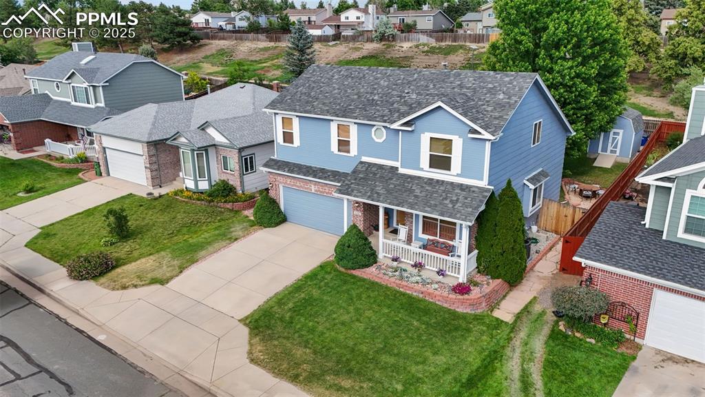 Image 2 of 48: Traditional home with covered porch, concrete driveway, brick siding, a gar
