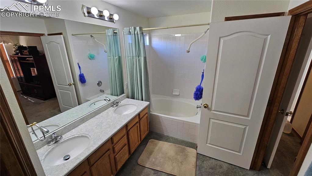Image 33 of 48: Bathroom featuring tiled shower / bath and double vanity