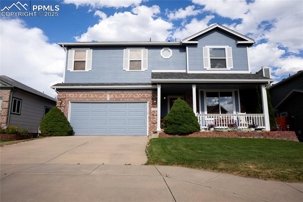 Image 48 of 48: View of front of house with covered porch, a garage, concrete driveway, a f