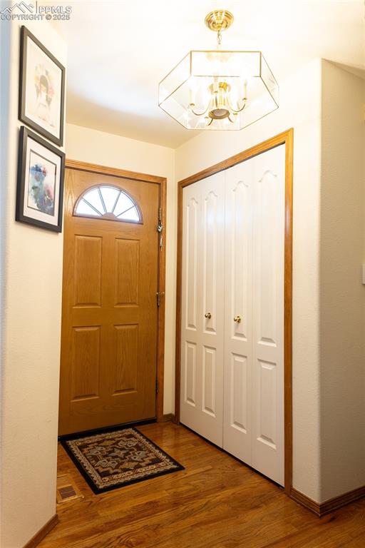Image 9 of 48: Foyer featuring a chandelier and wood finished floors