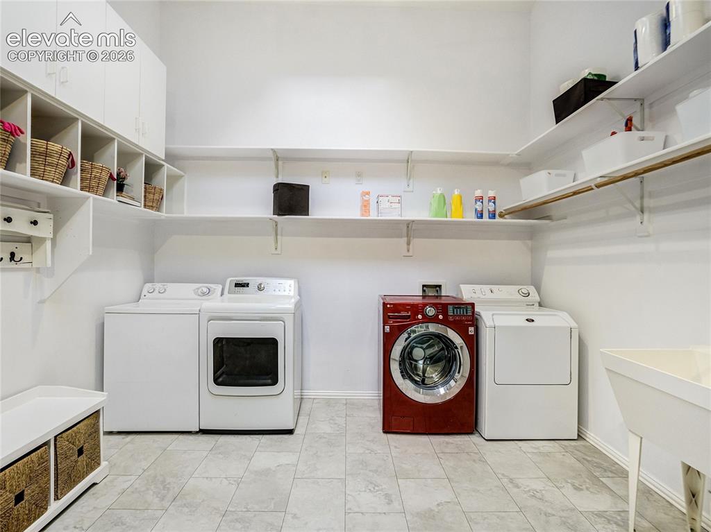 Image 21 of 50: Main level laundry room provides double washer and dryer space, with built-