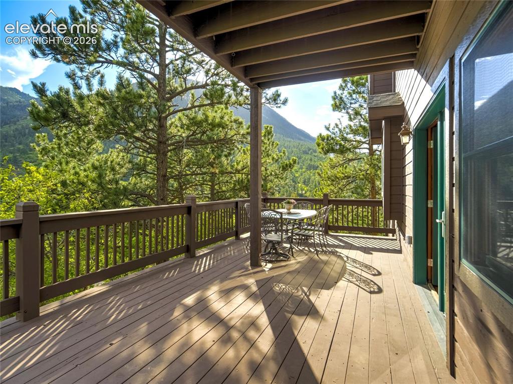Image 7 of 50: An expansive wrap around deck with mountain views sets the backdrop for nat
