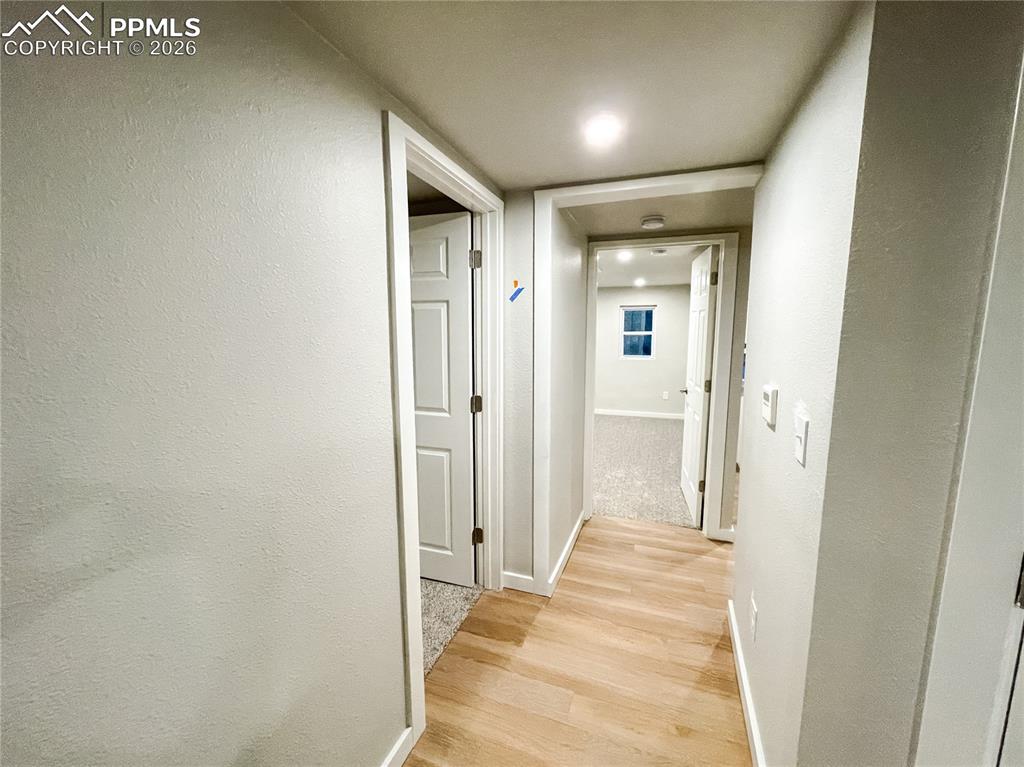 Image 16 of 24: Spacious room featuring wood-finish flooring, a contemporary accent wall, r