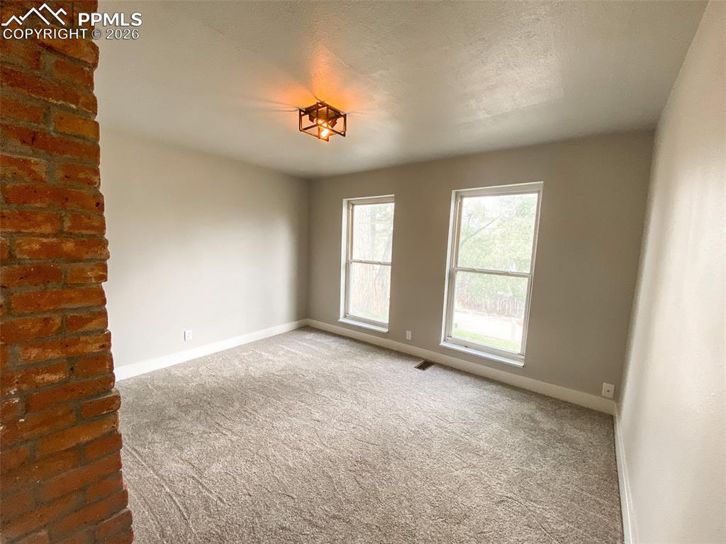 Image 8 of 24: Open living area featuring wood-finish flooring, light grey walls, and a co