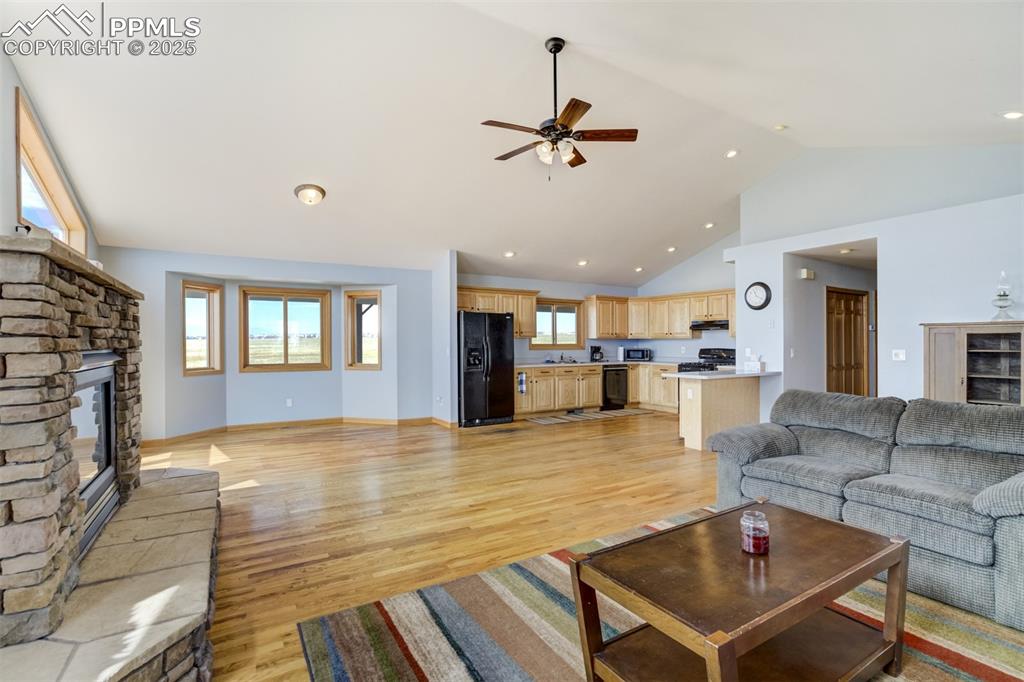 Image 11 of 50: Living room with a fireplace, ceiling fan, healthy amount of natural light,