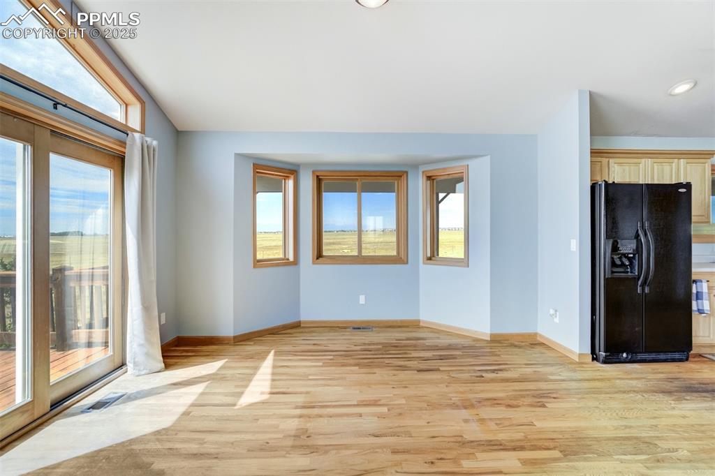 Image 13 of 50: Unfurnished living room featuring light wood-type flooring and baseboards